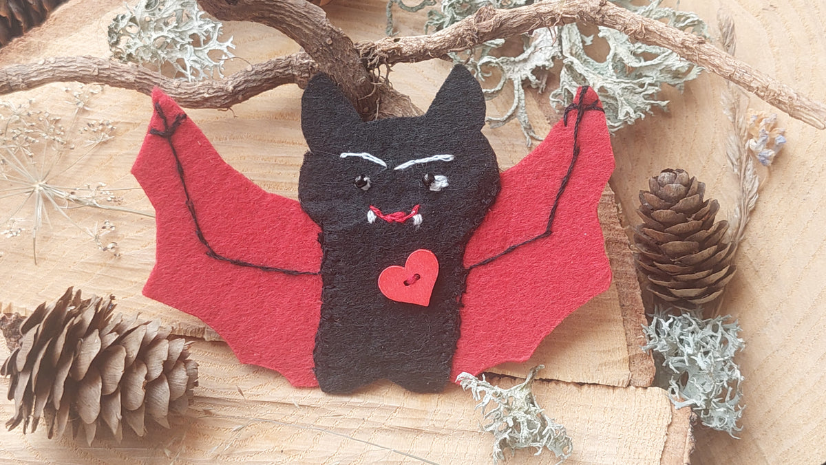 Handmade black felt vampire bat brooch with red wings and hand embroidery