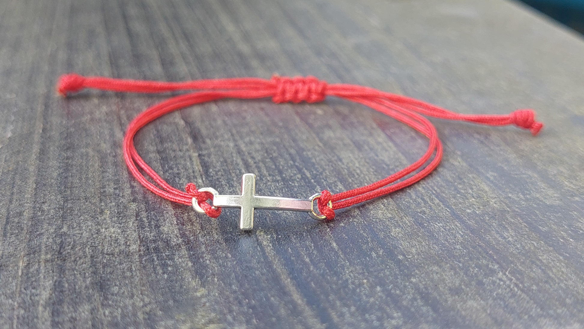 Handmade red macrame cross bracelet with silver-tone stainless steel charm, adjustable unisex design