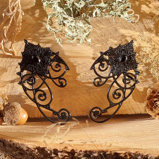 Black elf ear cuffs with crystals – gothic fantasy earrings for pierced ears.
Elegant black crystal elf ear jewelry for Halloween, cosplay, festivals and dark fantasy looks.