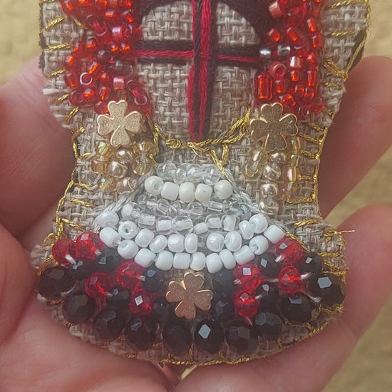 Back of handmade Ukrainian Motanka brooch showing textile base and pin closure